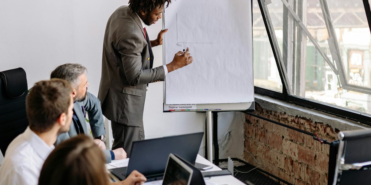 A confident individual presenting to a team, symbolizing the collective effort and strategic planning required to advance AI safety.