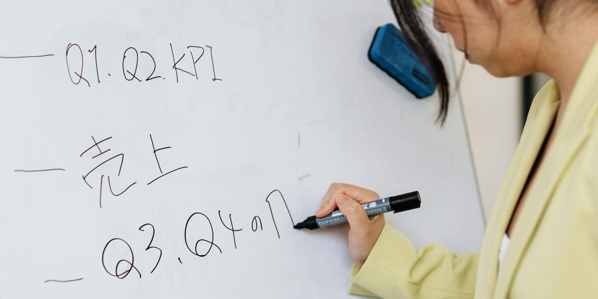 A person writing on a whiteboard, reflecting creative work involving text and typography in video projects.