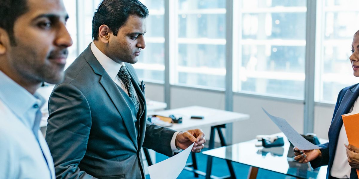 Professionals diligently reviewing documents, symbolizing the importance of compliance and trust in AI governance.
