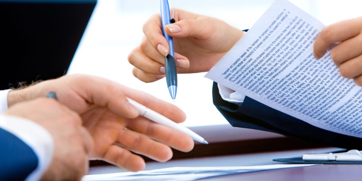 Two business professionals shaking hands in an office, symbolizing trust, compliance, and successful stakeholder engagement.
