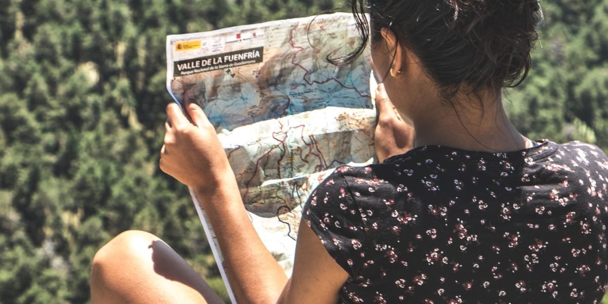 A person looks thoughtfully at a device, contemplating a route or decision, reflecting the need for trustworthy navigation.