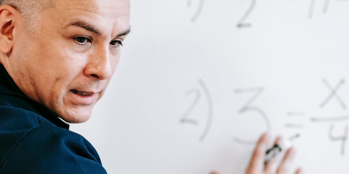 A professional uses a whiteboard to explain a complex concept, symbolizing the clarity and structured approach of the Value Reinforcement System.