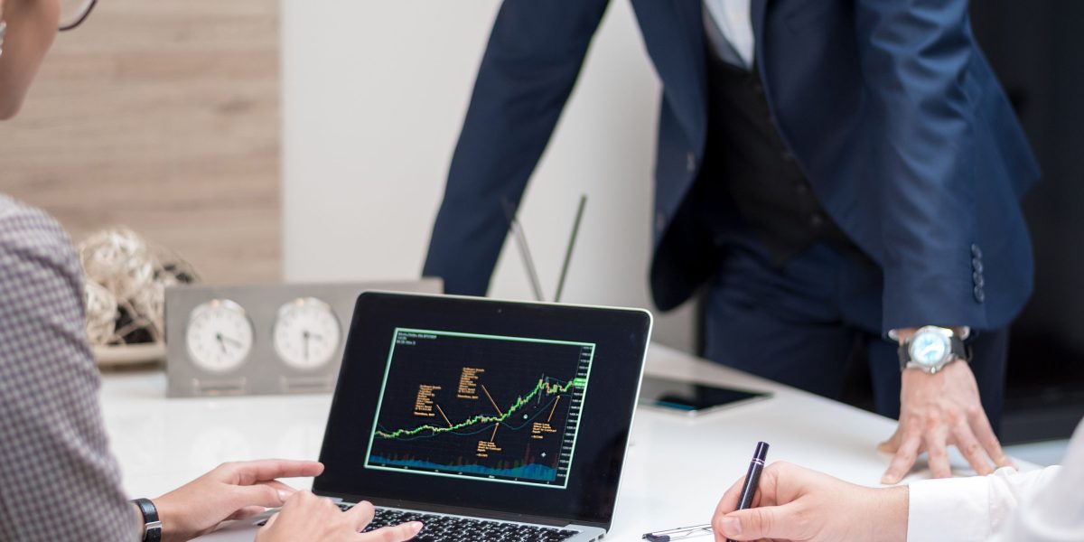 A team of professionals in an office setting, actively discussing financial reports or risk assessments, reflecting business challenges.