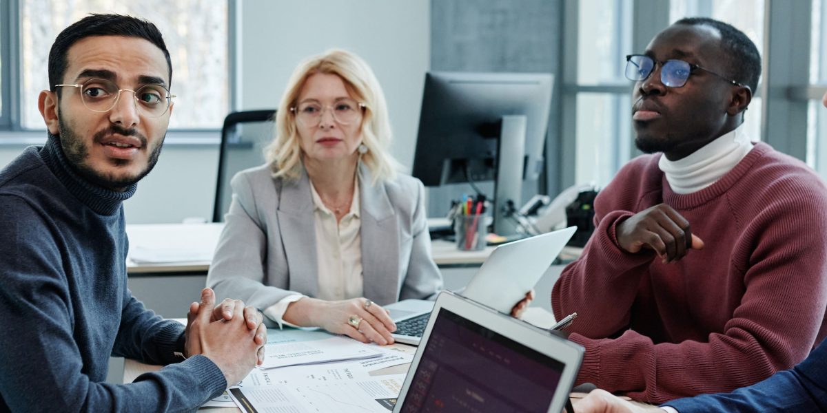 A team collaborates in a meeting, focusing on compliance and governance to responsibly manage AI risks.
